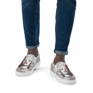 Puede incluir: Zapatillas blancas de lona sin cordones con una imagen en blanco y negro de la cara de Marilyn Monroe en la parte delantera.