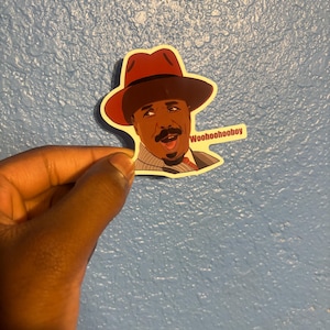 May include: A sticker featuring a cartoon illustration of a man wearing a fedora hat. The man has a mustache and is smiling with his mouth open. The sticker has the text "Woohoohooboy" on a small white rectangle.