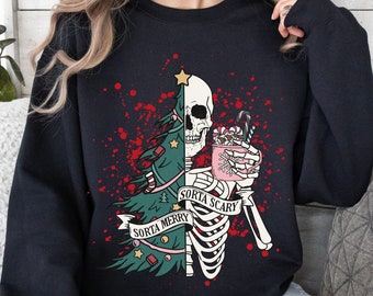 May include: Black sweatshirt with a graphic design featuring a skeleton and a Christmas tree. The skeleton holds a mug of hot cocoa and candy canes. The text reads "Sorta Merry Sorta Scary". Red splatter design.