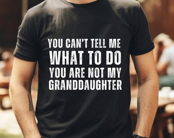May include: Black t-shirt with white text that reads: "YOU CAN'T TELL ME WHAT TO DO YOU ARE NOT MY GRANDDAUGHTER." The shirt is being worn by a person.