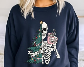 May include: Navy blue sweatshirt with a graphic design featuring a skeleton. One half of the skeleton is a Christmas tree, the other half is a skull holding a mug. The text reads "Sorta Merry Sorta Scary".