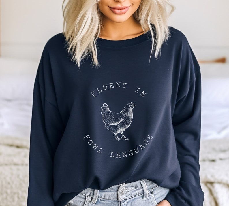 May include: A navy blue sweatshirt with a white graphic of a chicken and the text "Fluent in Fowl Language".