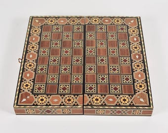 Könnte beinhalten: Ein rechteckiges Backgammon-Spielbrett aus Holz mit aufwendiger Intarsienarbeit und geometrischen Mustern in Braun-, Beige- und Cremetönen. Die Oberfläche zeigt ein Raster aus Quadraten mit eingelegten Stern- und Rautenmotiven.