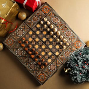 May include: A wooden game board with intricate inlaid designs in shades of brown, black, and white. The board is divided into two sections, one for chess and one for draughts. The chess pieces are arranged on the board, and the draughts pieces are in their starting positions.