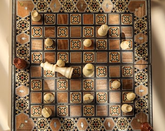 May include: A wooden chess board featuring intricate geometric marquetry borders with inlaid mother-of-pearl accents. The board contains light and dark wooden squares, some decorated with floral patterns, and scattered light and dark wooden chess pieces.