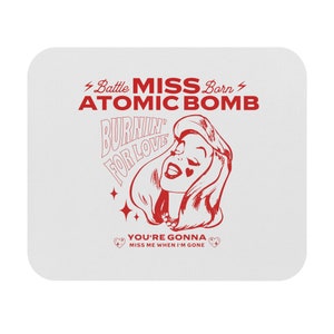 May include: Red and white graphic design with a woman's face and the text "Battle Miss Born Atomic Bomb Burnin' For Love You're Gonna Miss Me When I'm Gone".