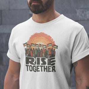 Camiseta Palestina (Rise Together): Camiseta unisex con banderas palestinas y diseño de atardecer, regalo solidario, ideal para él y para ella.