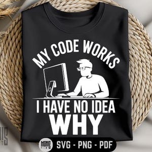 May include: Black t-shirt with white text that reads "My code works I have no idea why". The design also includes a white illustration of a person sitting at a computer.