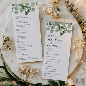 Może przedstawiać: Dwa programy ceremonii ślubnej z motywem liści eukaliptusa. Jeden program wymienia członków wesela, a drugi wita gości na ślubie Madison i Connor 22 marca 2027 roku. Programy znajdują się na białej marmurowej powierzchni.
