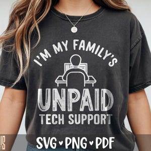 May include: A charcoal gray short-sleeve t-shirt featuring a white graphic of a person sitting at a computer desk. The text reads I'M MY FAMILY'S UNPAID TECH SUPPORT. The design has a distressed, weathered appearance on the fabric.