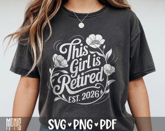 Könnte beinhalten: Ein anthrazitfarbenes Kurzarm-T-Shirt mit einem weißen Grafikdesign mit dem Text This Girl is Retired EST. 2026, umgeben von Blumenillustrationen. Das T-Shirt hat einen Rundhalsausschnitt und eine lockere Passform mit verwaschenem Vintage-Look.
