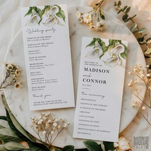 May include: Two wedding program cards featuring white calla lily floral designs. One card lists the wedding party, and the other welcomes guests to Madison and Connor's wedding on 22 March 2027, with the ceremony details.