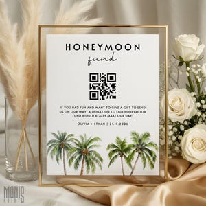 May include: A rectangular sign in a gold frame featuring the text HONEYMOON fund, a QR code, and the message IF YOU HAD FUN AND WANT TO GIVE A GIFT TO SEND US ON OUR WAY, A DONATION TO OUR HONEYMOON FUND WOULD REALLY MAKE OUR DAY! OLIVIA + ETHAN | 24.4.2026 with palm trees.