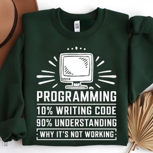 May include: A dark green sweatshirt with a white graphic of a computer monitor and the text "PROGRAMMING 10% WRITING CODE 90% UNDERSTANDING WHY IT'S NOT WORKING."