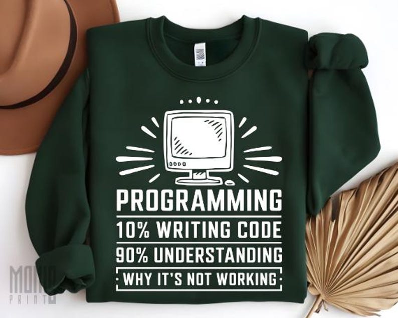 May include: A dark green sweatshirt with a white graphic of a computer monitor and the text "PROGRAMMING 10% WRITING CODE 90% UNDERSTANDING WHY IT'S NOT WORKING."