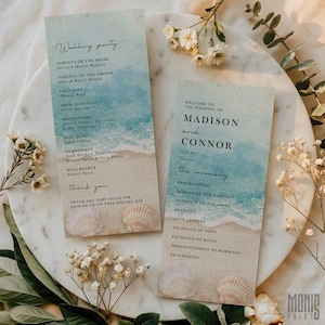 Puede incluir: Dos programas de ceremonia de boda con temática de playa. Los programas presentan un diseño de acuarela de una playa con conchas marinas. El texto incluye los detalles de la fiesta de bodas y el programa de la ceremonia. Los programas están sobre una superficie de mármol con flores.