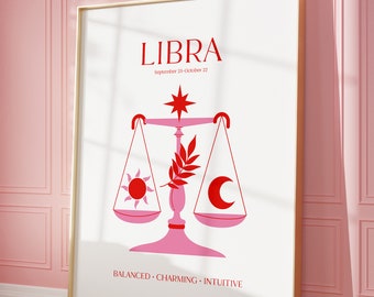 May include: A white poster with a gold frame featuring a pink Libra zodiac sign with a red star, sun, and moon. The text "LIBRA" is in red, and the text "September 23-October 22" is in black. The text "BALANCED. CHARMING. INTUITIVE" is in black.
