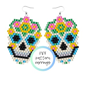 Könnte beinhalten: Ein Paar Perlenohrringe mit einem Totenkopfdesign und floralen Akzenten. Die Ohrringe sind aus bunten Perlen in den Farben Rosa, Gelb, Grün, Blau und Weiß gefertigt. Das Totenkopfdesign ist mit schwarzen Perlen umrandet. Die Ohrringe sind an silbernen Haken befestigt. Der Text "PDF pattern earrings" ist auf dem Bild zu sehen.