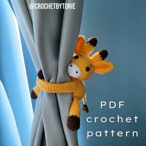 May include: A crocheted giraffe toy in yellow and brown is holding a curtain with its arms. The text "PDF crochet pattern" is written in white on a blue background.