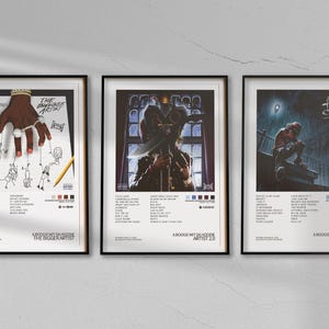 Könnte beinhalten: Drei schwarze gerahmte Poster mit weißen Hintergründen und bunten Grafiken. Die Poster sind mit "The Bigger Artist", "A Boogie Wit Da Hoodie Artist 2.0" und "A Boogie Wit Da Hoodie Hoodie SZN" betitelt.