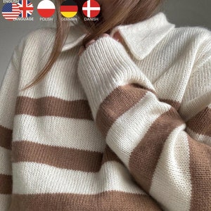 May include: A white and brown striped knitted jumper with a collared neckline. The jumper is made of a soft, cosy material and has a relaxed fit.