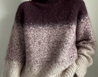 May include: A cozy, oversized sweater in a gradient of colors, transitioning from a deep burgundy at the turtleneck to a light beige at the hem. The knitwear features a ribbed hem and cuffs, offering a comfortable and stylish look.