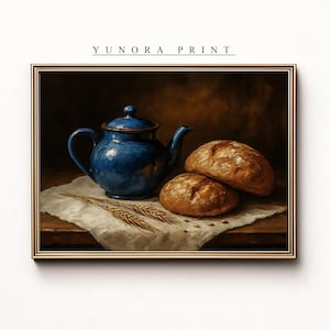 Puede incluir: Impresión enmarcada que representa una tetera azul, dos hogazas de pan y espigas de trigo sobre un paño blanco. La impresión tiene un marco dorado y el texto "YUNORA PRINT" en la parte superior.