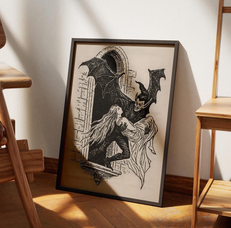 May include: Black and white framed print depicting a gothic scene. A winged demon figure embraces a woman in a window. The artwork features detailed linework and a vintage aesthetic, perfect for Halloween or gothic decor.