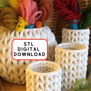 Peut inclure: Trois porte-fils en crochet blanc avec un motif tissé. Le plus grand porte-fils porte le texte "STL DIGITAL DOWNLOAD". Les porte-fils sont remplis de fils de couleur.