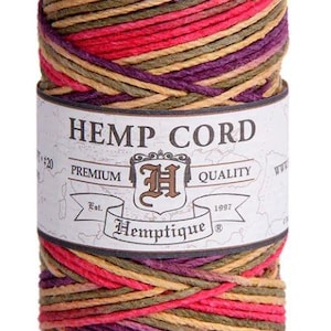 May include: A spool of Hemp Cord with a label that reads "Hemptique". The cord is a mix of red, purple, green, and tan colours. The top of the spool is a brown colour.
