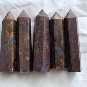 Puede incluir: Seis puntas de piedras preciosas pulidas, multicolores, cada una con una punta puntiaguda y una base hexagonal. Las puntas son una mezcla de rojo, marrón, verde y azul.