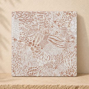 Puede incluir: Un lienzo cuadrado con un patrón animal abstracto en capas en tonos terracota, crema y blanco. El diseño incorpora varias texturas, incluyendo manchas de leopardo, rayas de cebra y formas orgánicas a lo largo de toda la superficie.