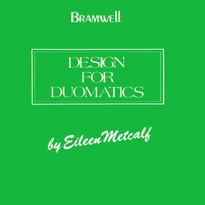 May include: A book cover with a bright green background. The title "DESIGN FOR DUOMATICS" is in a white rectangular box. The author's name, "by Eileen Metcalf", is in a cursive font. The publisher's name, "Bramwell", is at the top.