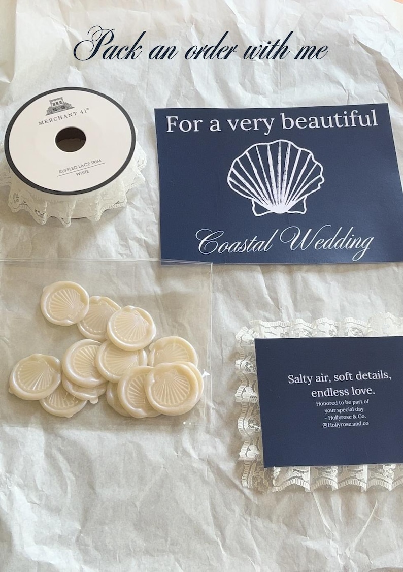 K&ouml;nnte beinhalten: Eine Auswahl an Hochzeitsartikeln, darunter wei&szlig;e Spitzenborte, marineblaue Karten mit Muscheldesign und Wachssiegel. Der Text "Pack an order with me" und "Coastal Wedding" sind ebenfalls zu sehen.