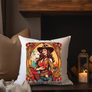 May include: White pillow with a colorful illustration of a woman wearing a cowboy hat and holding playing cards. The text "LADY LUCK" is printed below the illustration.