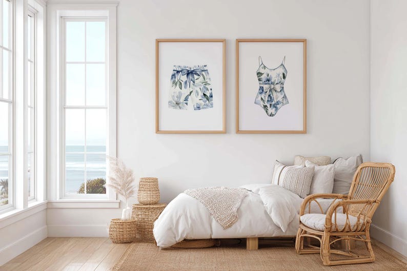 Add a touch of coastal elegance to your home with this coordinated set of two floral swimwear watercolor prints. Featuring a matching one-piece swimsuit and swim trunks adorned with soft blue florals and botanical accents, this collection blends vintage beach charm with sophisticated coastal style. Perfect for bathrooms, beach houses, lake cottages, dressing rooms, pool houses, and summer-inspired interiors.