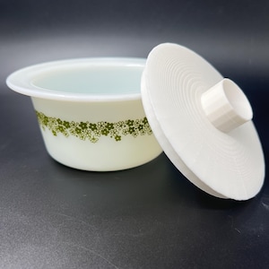 May include: White ceramic bowl with a green floral pattern and a matching lid. The lid has a raised knob on top.