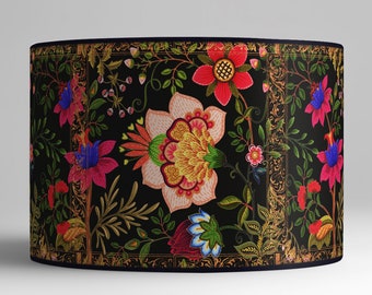 May include: A black lampshade with a floral pattern featuring pink, red, yellow, blue, and green flowers on a black background. The lampshade has a gold trim around the edges.