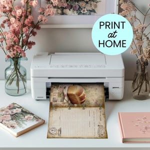 May include: A white printer is printing a vintage-style recipe sheet with a loaf of bread image. The sheet has a rustic design with a scale illustration and the text "Recipe". The image also includes pink flowers in vases and a notebook.