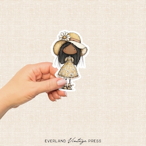 May include: A sticker of a cartoon girl in a yellow floral dress and a straw hat with a daisy. The sticker has a white border and is held by a hand. The text "EVERLAND Vintage PRESS" is at the bottom.