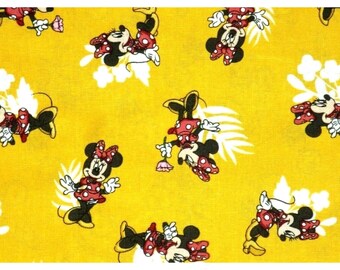 Puede incluir: Tela amarilla con un patrón repetido de Minnie Mouse en varias poses. Minnie se representa con su vestido y lazo de lunares rojos y blancos característicos. También hay detalles florales y de hojas blancas.