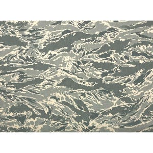 May include: A digitally rendered camouflage pattern in shades of gray, white, and blue. The design features a pixelated, flowing pattern reminiscent of a topographical map or water currents. The fabric appears to be a durable material, suitable for various applications.