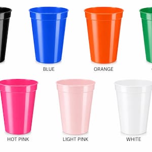 Puede incluir: Siete vasos de pl&aacute;stico dispuestos en dos filas. La fila superior presenta vasos negros, azules, naranjas y verdes. La fila inferior presenta vasos rosa intenso, rosa claro y blancos. Cada vaso tiene un dise&ntilde;o c&oacute;nico liso con un borde ancho.