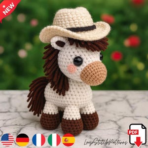 May include: A crocheted white horse with brown mane, tail, and hooves, wearing a beige cowboy hat with a black band. The horse has pink cheeks and large black eyes. The image includes the text "NEW" and "LoopStitchPatterns".