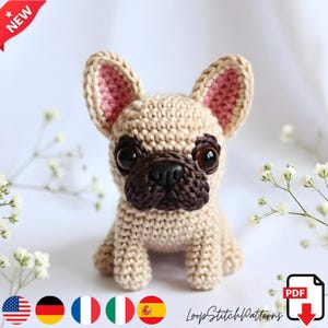 Può includere: Un bulldog francese beige all'uncinetto con dettagli marroni, grandi occhi neri e orecchie interne rosa. Il cane fatto a mano è seduto in posizione eretta. L'immagine include il testo "NEW" e "LoopStitchPatterns".