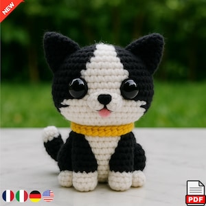 Könnte beinhalten: Ein handgehäkelter Hund mit schwarz-weißem Fell, großen schwarzen Augen und einem gelben Halsband. Der Hund hat eine rosa Zunge und sitzt aufrecht. Das Wort "NEW" steht in einem roten Banner in der oberen linken Ecke.