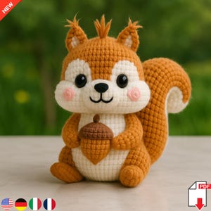 May include: A handmade crochet squirrel toy in shades of brown, white, and peach. The squirrel is holding a brown acorn and has a fluffy tail. The toy has large black eyes and pink cheeks. The word "NEW" is in the top left corner.