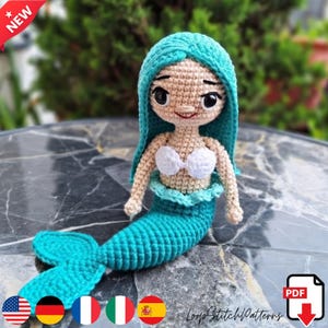 May include: A handmade crochet mermaid doll with turquoise hair and tail, a white seashell top, and a smiling face. The doll is labeled "NEW" and includes a PDF download icon.