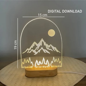 May include: A digital download for a 15 cm by 19 cm acrylic night light with a design of mountains, trees, and a moon. DIGITAL DOWNLOAD text is visible at the top of the image.