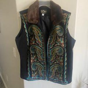 May include: Black sleeveless vest with a faux fur collar and intricate embroidery in shades of teal, gold, and brown.